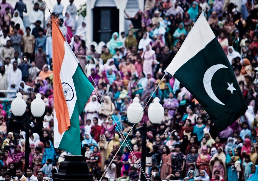 The flags of India and Pakistan are lowered simultaneously at the Wagah Border. The crowd on the Pakistani side of the border