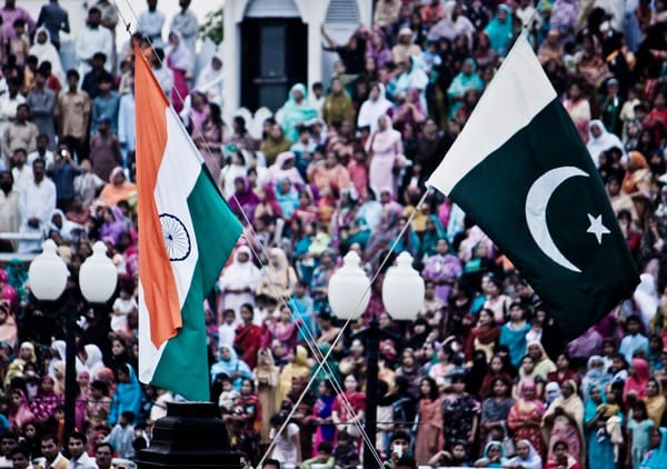 The flags of India and Pakistan are lowered simultaneously at the Wagah Border. The crowd on the Pakistani side of the border
