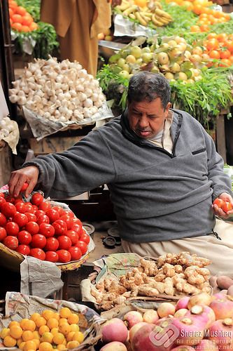 A vegetable seller busy decorating his shop