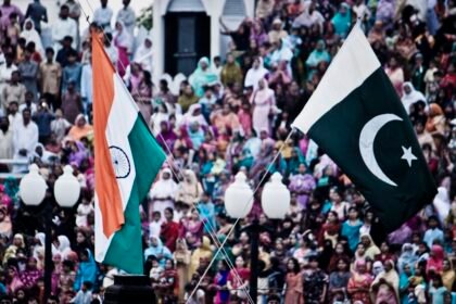 The flags of India and Pakistan are lowered simultaneously at the Wagah Border. The crowd on the Pakistani side of the border are pictured.